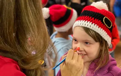 girl getting face painted at Christmas time