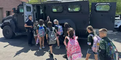 officer showing children the swat truck on a tour