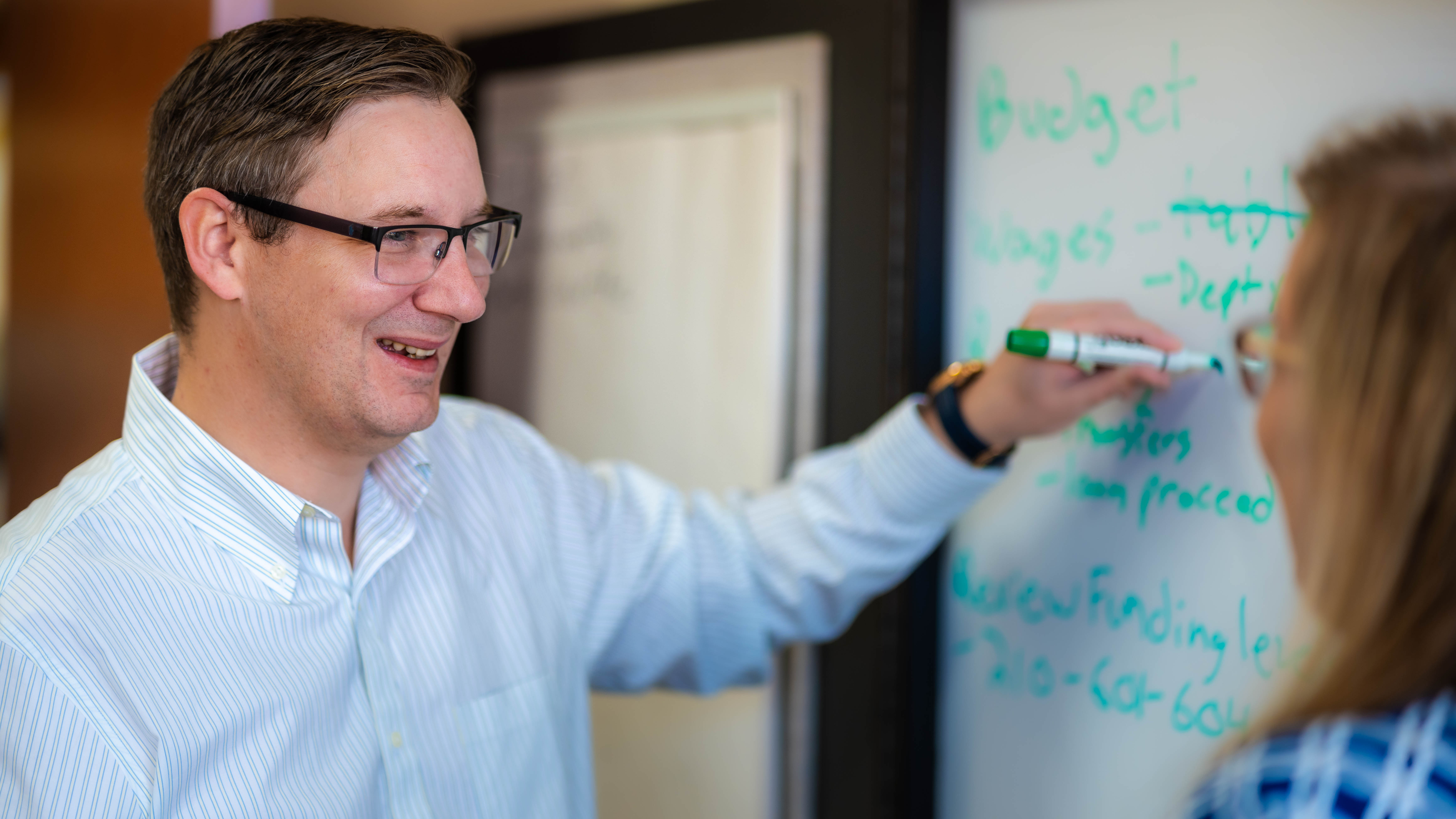 Finance Director Robert Drexler works on problem with coworker at white board