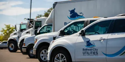 Fleet of Bullhead City Utilities vehicles parked in front of the Bullhead City Administration Complex.  