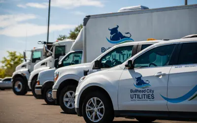 Fleet of Bullhead City Utilities vehicles parked in front of the Bullhead City Administration Complex.  