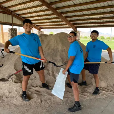 three young men filling sand bags