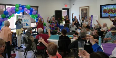Community of seniors makes a non-alcoholic toast at the celebration of the grand opening of the Senior Enrichment Center