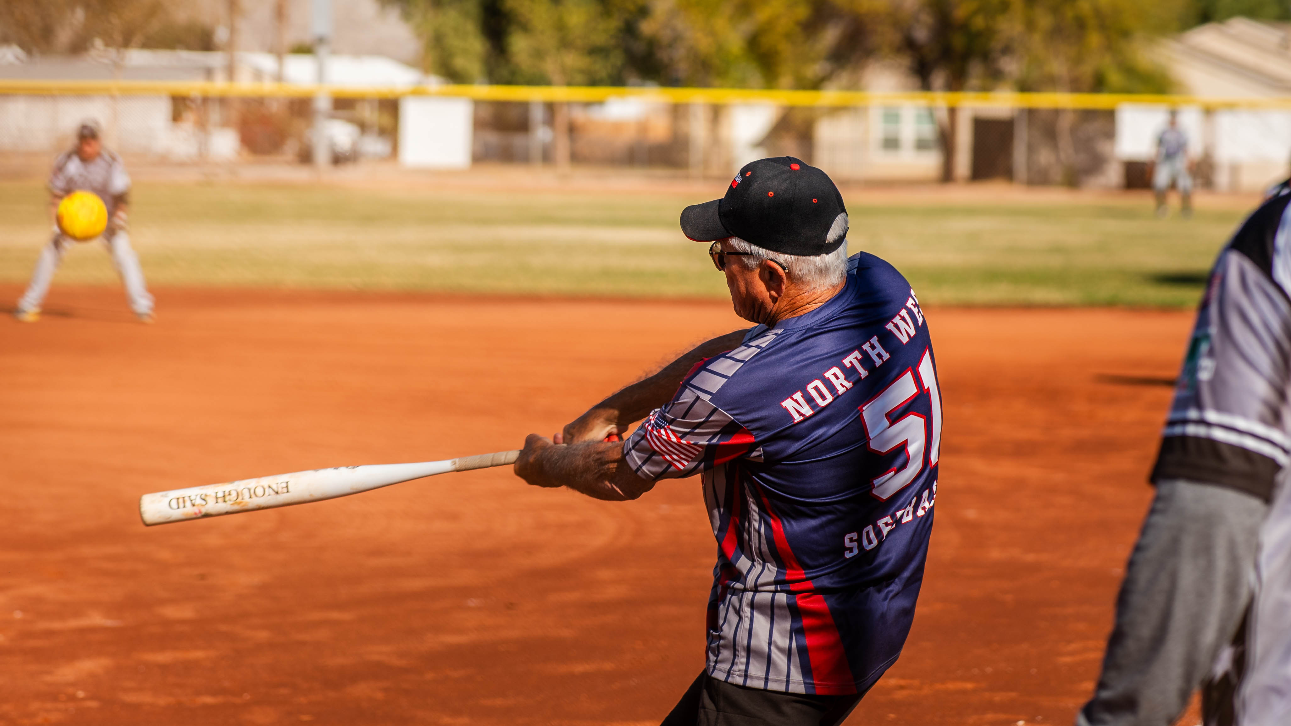 Man swings at ball during senior softball game