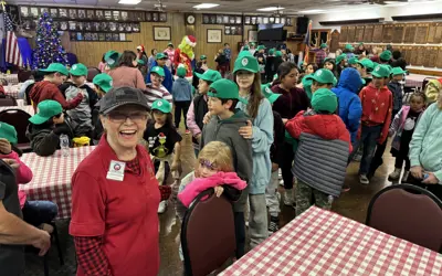 volunteer helping give children a Christmas breakfast
