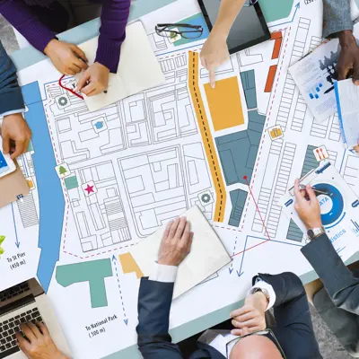 Meeting setting with several people reviewing documents 