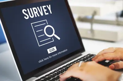 Laptop on a desk with an online survey visible on the screen