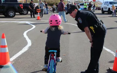 police officer helping girl ride a bike