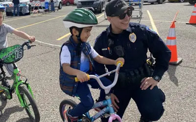 police officer helping a boy on a bicycle