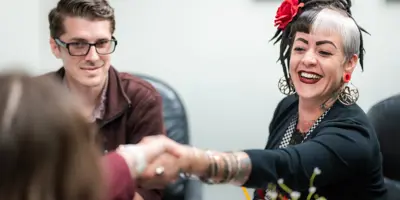 Job applicant shakes hand with job interview panel at interview