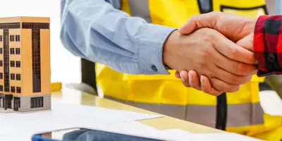 Men in construction vest shacking hands